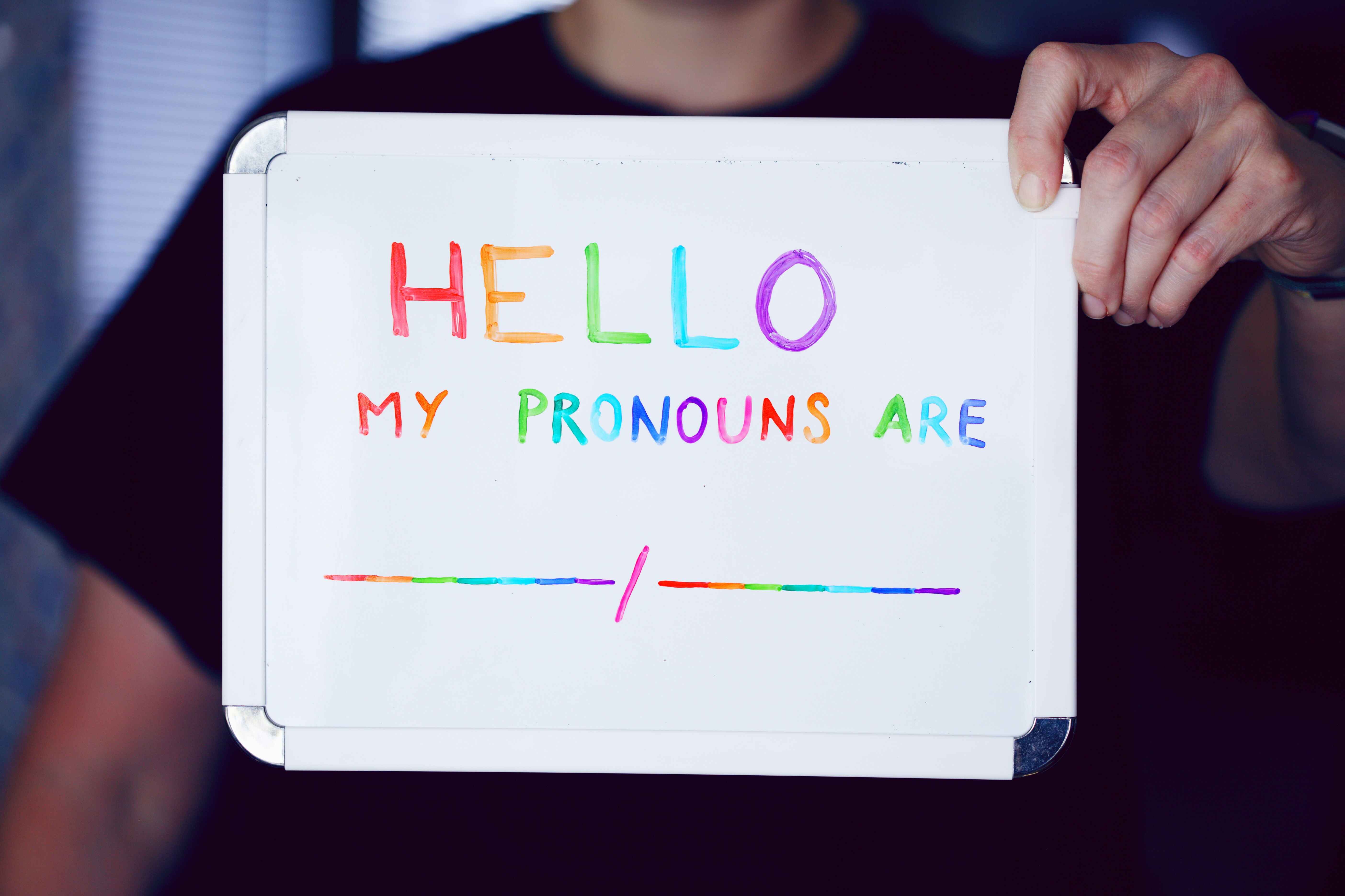 mini lousa escrito 'hello my pronouns are' com uma linha em branco para completar com o pronome pessoal em inglês