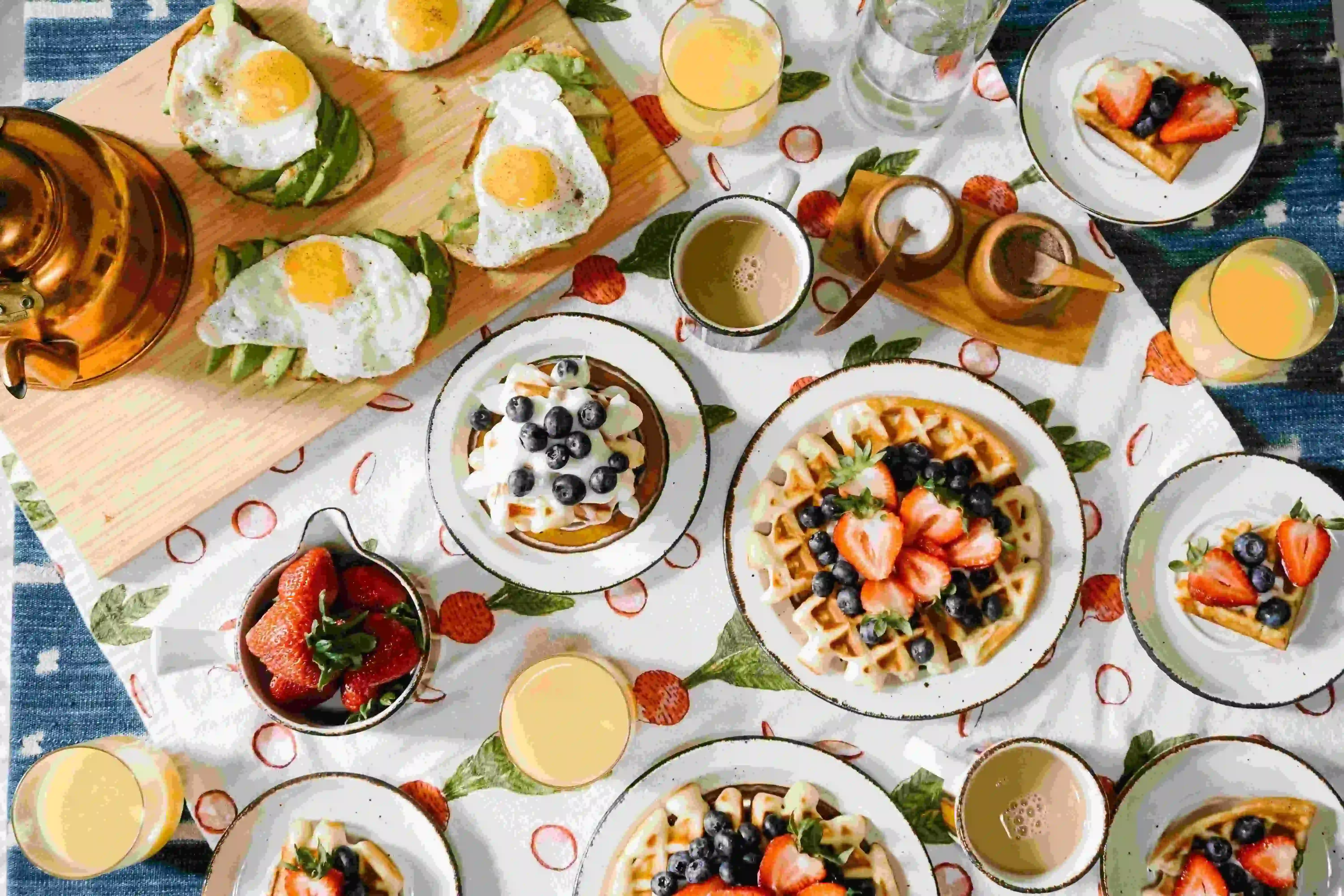 mesa com vários pratos de comidas típicas de café da manhã americano