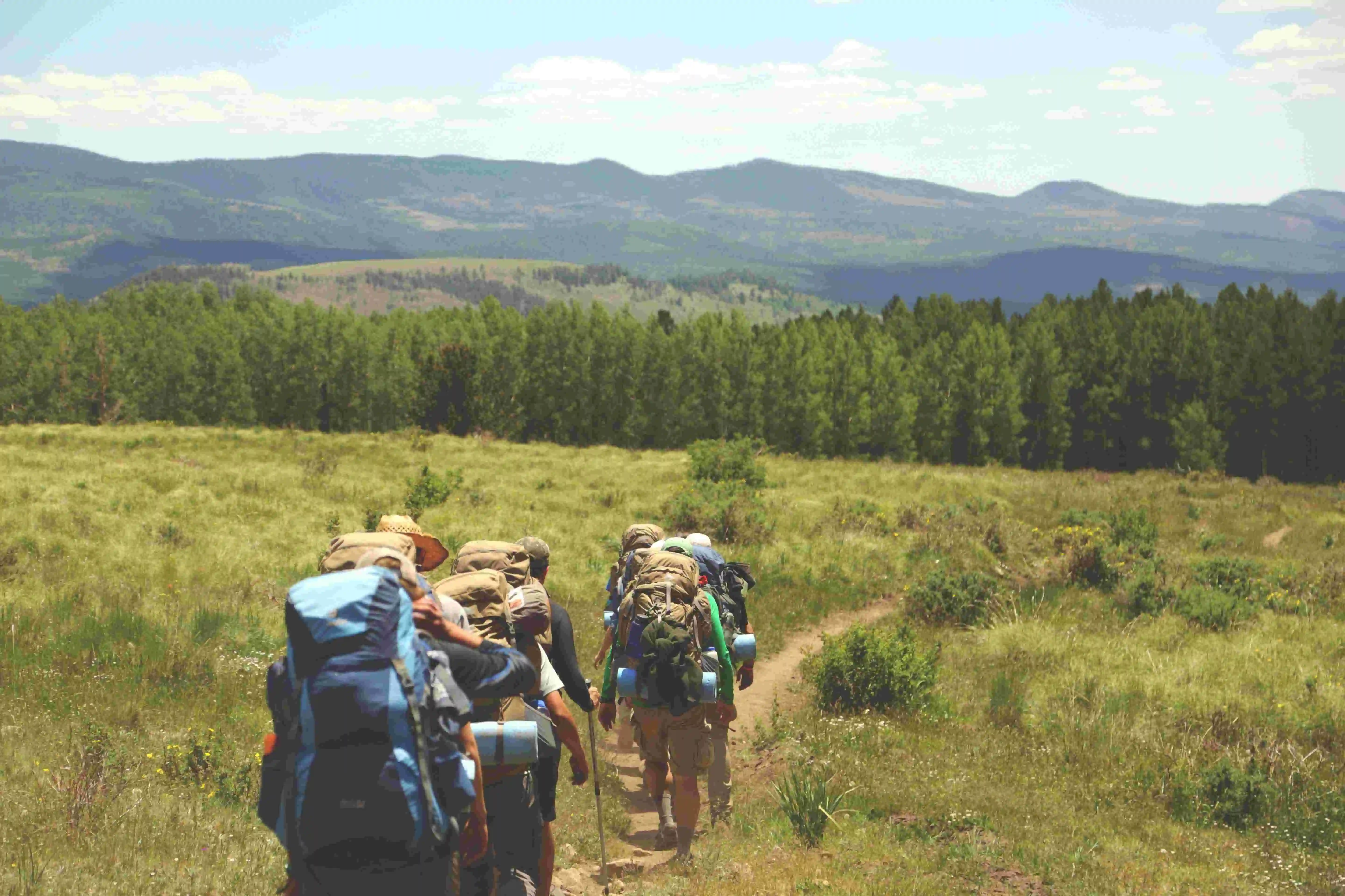 grupo fazendo trilhas nas montanhas com um caminho contínuo